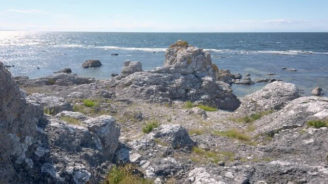 Rauk field by sea on sunny morning, Gotland landscape, Sweden, tilt up
