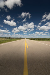 A scenic route along a prairie Highway in Northern Alberta under a deep blue sky.