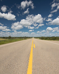 A scenic route along a prairie Highway in Northern Alberta under a deep blue sky.