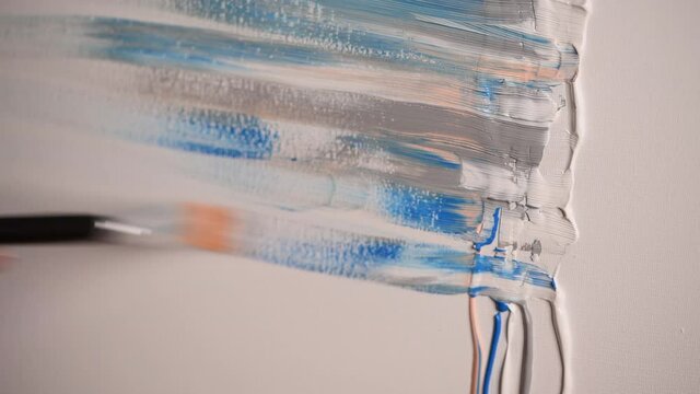 Fmale artist draws abstract picture, pastel colours acrylic paint and palette