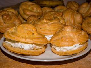Profiterole or cream puff filled with whipped creamon a white plate