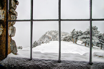 Looking Through a Window of a Hut into a Mountaintop Snowstorm 
