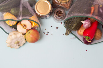vegetables, fruits and cereals in an eco bag on a blue background and place for text.