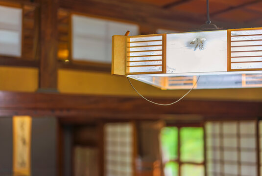 Close-up on a traditional polygonal pendant light ornate with a shape of the mount Fuji in a Japanese-style room.