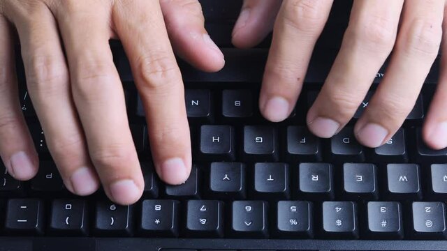 4K Top view Close up Man hands type ona keyboard working at home. Hands touch typing keyboard use internet for cloud data social network media searching. Work from home new normal concept.