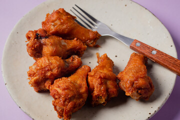 Fried chicken in ceramic plates with cutlery on the side.