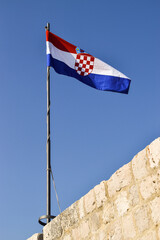 Croatia flag flying over a stone wall, in Dubrovnik.