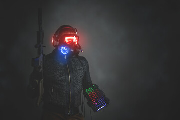 Futuristic cyberpunk soldier with a rifle and computer keyboard on gray background with copy space.
