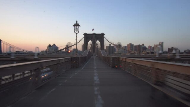 Hyper Lapse over Empty Brooklyn Bridge at Sunrise with few people in times of Coronavirus Covid 19 Pandemic