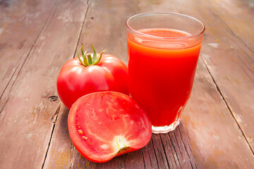 tomato juice in a glass and tomatoes