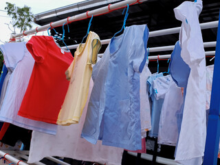 Colorful kid clothes drying on hanger outside the house. Washing and cleaning are generally housewok but are very important espeacially during covid 19 situation.