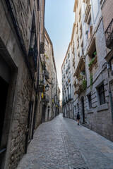 Fototapeta na wymiar Views of the narrow streets of the old town of Girona with a woman.