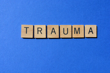 Trauma, word in wooden alphabet letters isolated on blue background