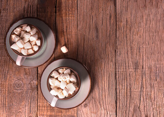 Hot chocolate with cinnamon and marshmallow on wooden background