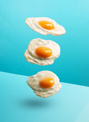 Three flying eggs on the modern blue background