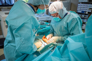 2 doctors operate on a wrist fracture in an operating theatre