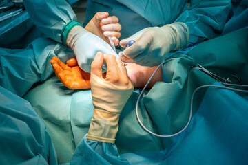 2 doctors operate on a wrist fracture in an operating theatre