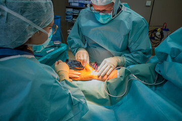 2 doctors operate on a wrist fracture in an operating theatre