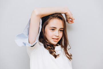 Naklejka premium little pretty girl with expressive facial features posing for a photo on a gray background