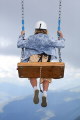 The girl took off on a swing into the clouds.