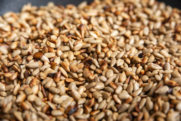 Fried sunflower seeds in a frying pan, peeled.