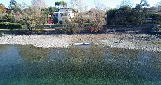 Shot of small boat filmed with a drone. The lake is called LagoMaggiore and its situated in northern italy.
