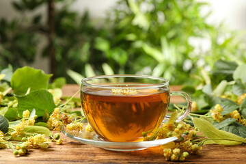 Cup of tea and linden blossom on wooden table
