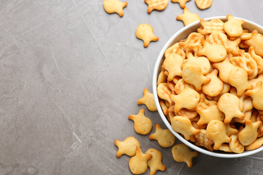 Delicious Goldfish Crackers In Bowl On Grey Table, Flat Lay. Space For Text