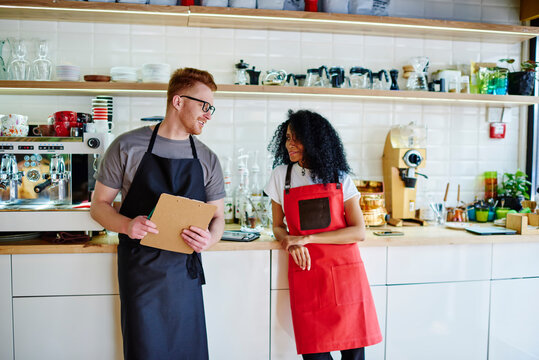 Playful barista having fun with partner in cafe