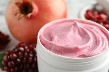 Jar of facial mask and fresh pomegranate, closeup. Natural organic cosmetics
