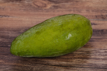 Green tasty mango over wooden background