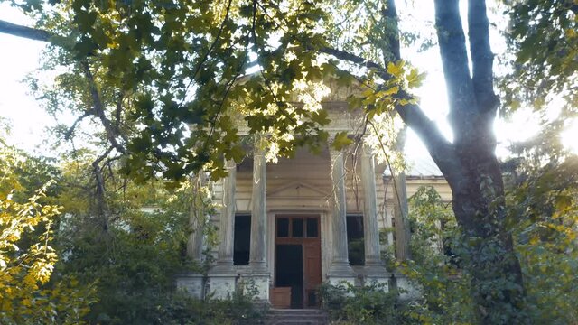 Abandoned 19th century palace (manor or mansion house) with columns in Neoclassical style. Old deserted building. Aerial low angle view