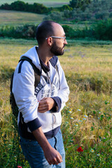 Young man hiking through a peaceful meadow.