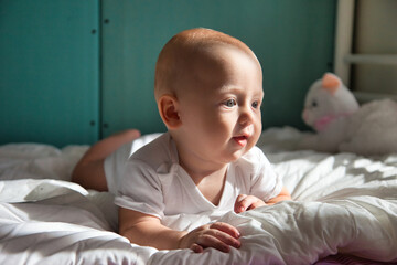 Toddler 6 months lies on his tummy and shows emotions