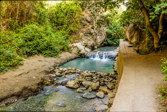 A long exposure shot of the Monachil river cascading over a small weir in the Sierra Nevada mountains, Spain in the summertime