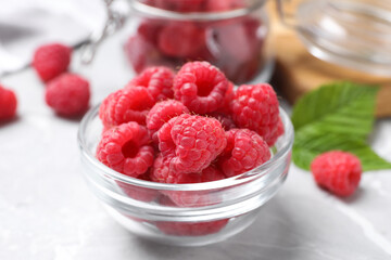 Delicious fresh ripe raspberries on light grey table, closeup