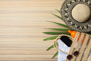 Flat lay composition with smartphone and beach objects on wooden background. Space for text