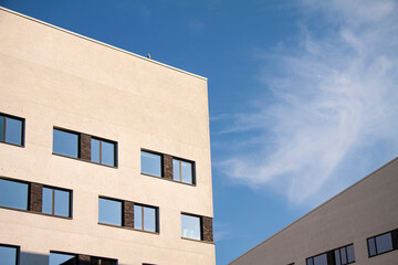 Modern white office buildings with blue sky and light white clouds background. Image with copy space.