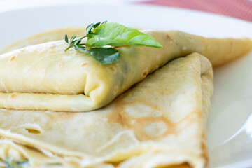 Detail shot of crepes served on a white plate