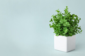 Beautiful artificial plant in flower pot on grey background, space for text