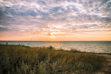 Golden sunrise at the sea on a cloudy morning. Ships can be seen against the background of sunrise on the horizon. Black sea. Sanzhiika. Ukraine