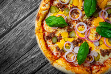 Pizza with Mozzarella cheese, Bolognese sauce, minced meat and vegetables. Italian pizza on wooden background.