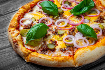 Pizza with Mozzarella cheese, Bolognese sauce, minced meat and vegetables. Italian pizza on wooden background.