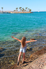 Young girl with her arms outstretched enjoying sea view