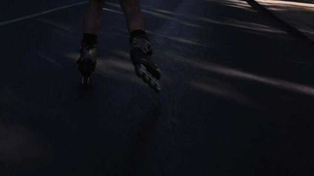 Plano corto patines por carretera en sombra con rayos de luz al atardecer oscura corriendo libertad felicidad