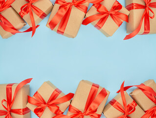 Frame from gifts on a blue background. Paper gift boxes with red bows. Holiday decorations. Baner. Copy of space.
