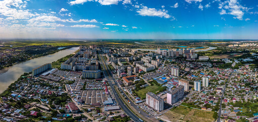 summer panorama of the large YUMR microdistrict in Krasnodar, which is built up with multi-storey buildings in 1990-2010. Bend of the Kuban River - obrazy, fototapety, plakaty
