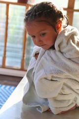 a little girl looks out of the bathroom window