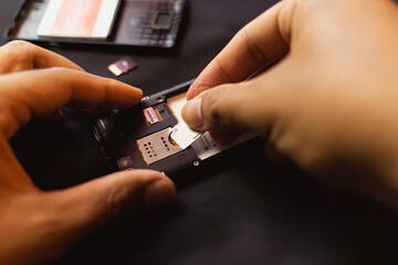 Employees are changing the phone SIM card, nano SIM card in the shop for customers to buy, Man's hand.