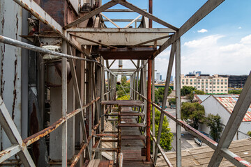 Fototapeta na wymiar Pedestrian overpass in old factory. rusty metal, dangerous place.